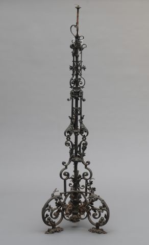 null Wrought iron floor lamp resting on a tripod base with scrolls, decorated with...