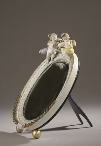  Petit miroir à poser, l'encadrement en porcelaine polychrome cerné d'un filet doré,...
