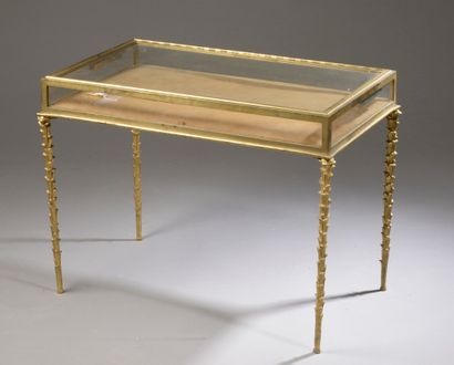 null Table basse en bronze ciselé et doré, le plateau rectangulaire formant vitrine...