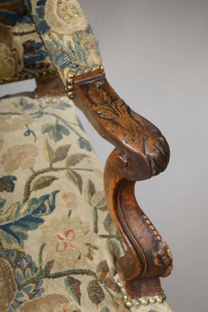 null Armchair with high back in walnut molded and finely carved with fleurons, the...