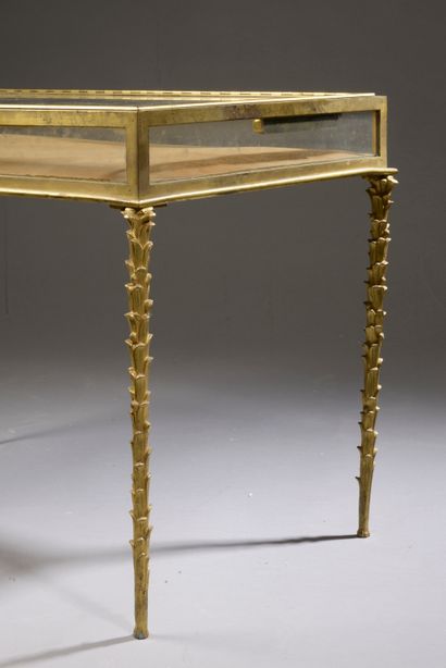 null Table basse en bronze ciselé et doré, le plateau rectangulaire formant vitrine...