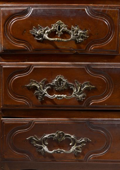 null Molded walnut chest of drawers, the front slightly curved opening to four drawers...