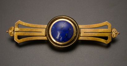 null 18k yellow gold brooch with a lapis lazuli cabochon in a black enamel setting.

Accompanied...