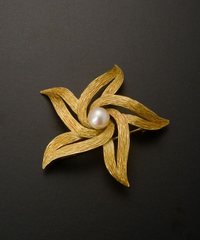 18k yellow gold brooch featuring a swirling...