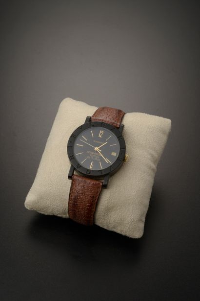 null BULGARI.

Wristwatch, round carbon case, black dial with gold index and date...