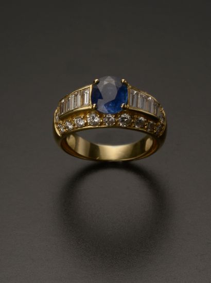 18k yellow gold ring presenting an oval sapphire...