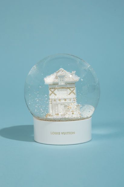 null LOUIS VUITTON. 

Boule à neige en verre sur socle en plastique laqué blanc figurant...