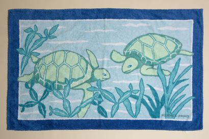 null HERMÈS.
Drap de plage en coton éponge à motifs de tortues nageant dans les tons...