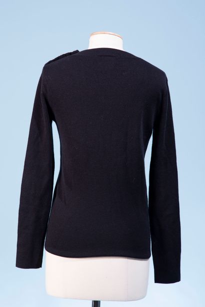 null CHANEL Uniform.
Black wool sweater, closed on the shoulder by three semi-hemispheric...