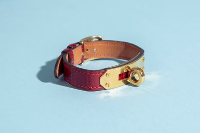 null HERMÈS.
Kelly" bracelet in burgundy crocodile, the jewelry in gold metal. With...