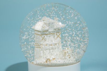 null LOUIS VUITTON. 

Boule à neige en verre sur socle en plastique laqué blanc figurant...
