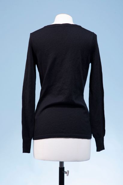 null CHANEL Uniform. 
Black wool sweater, the round neck split and decorated with...