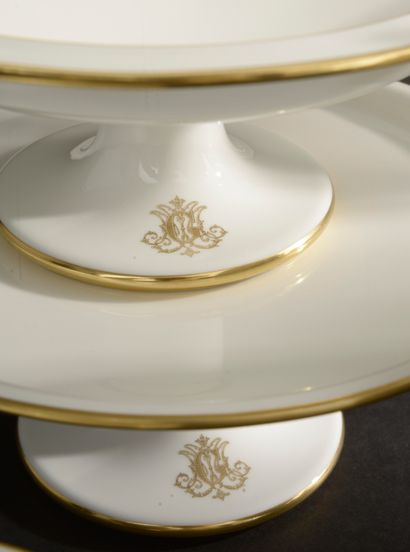 null SÈVRES.
Part of table service in white enamelled porcelain with gold net. Monogrammed...
