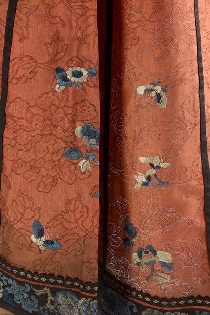 null CHINE - Vers 1900.
Jupe en soie rouge à décor brodé aux fils bleus dit "sanlan"...