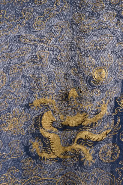 null CHINE - XIXe siècle.
Robe jifu en gaze de soie bleue brodée aux fils dorés de...