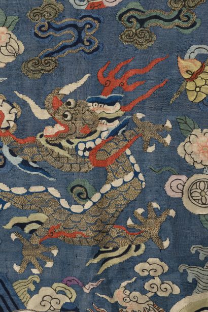 null CHINE - XIXe siècle.
Robe jifu en kesi bleu à décor de neuf dragons pourchassant...