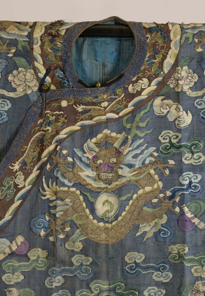 null CHINE - XIXe siècle.
Robe jifu en kesi bleu à décor de dragons pourchassant...