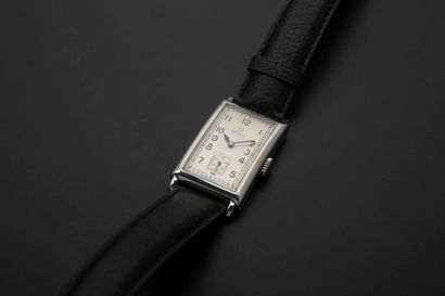 null OMEGA.
Steel wristwatch, the domed rectangular case, the silver dial with Arabic...