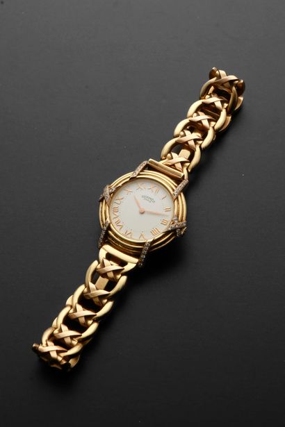 null HERMÈS "Ruban".
Ladies' wristwatch in 18k yellow gold, round case, white dial...