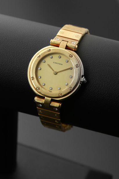null CARTIER "Santos".
Ladies' wristwatch in brushed 18k yellow gold, the round case...
