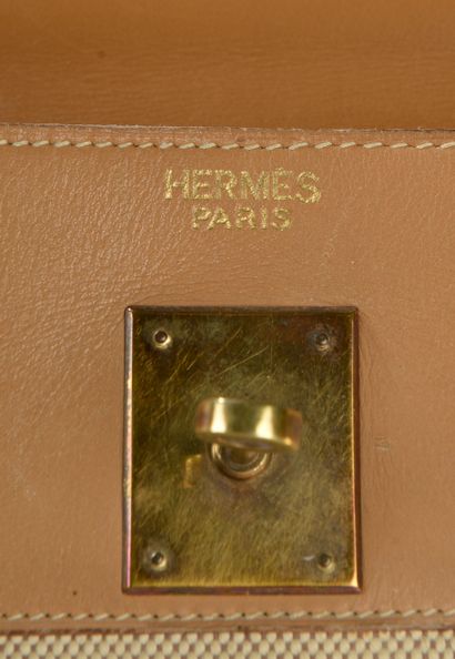null HERMÈS. 
Kelly" bag 32 cm in smooth gold leather and canvas H, the jewelry in...