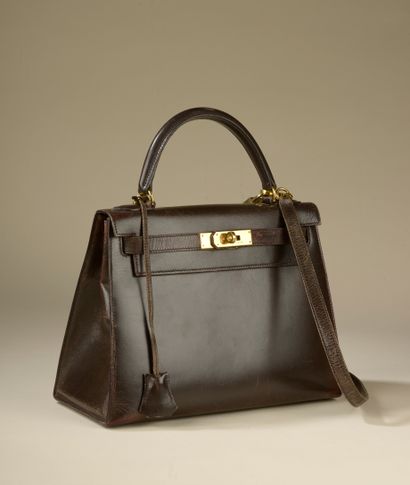 null HERMÈS. 
Bag "Kelly" 28 cm saddle in brown box calf, the jewelry in gold metal,...