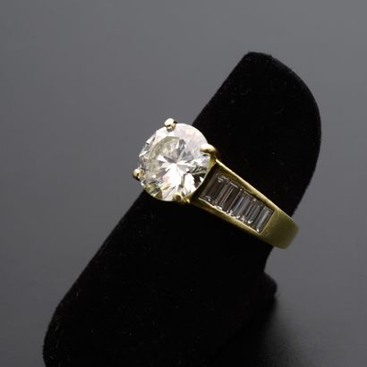 null Bague en or jaune 18k présentant un diamant de taille brillant moderne, épaulé...