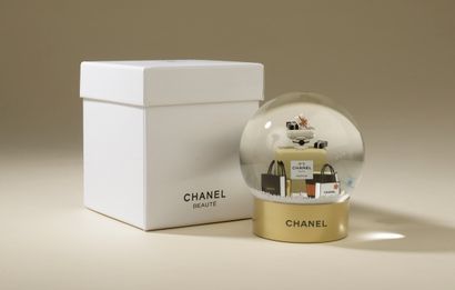 CHANEL. 
Glass snow globe on a gold lacquered...