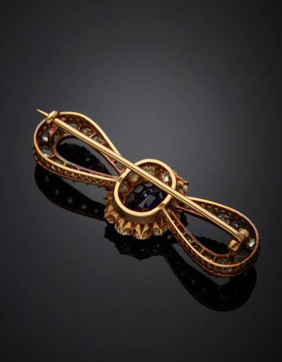 null 18k yellow gold bow brooch presenting an oval cut sapphire of about 3.50 cts...