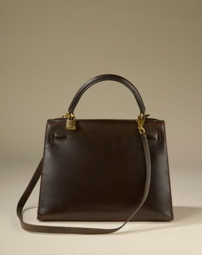 null HERMÈS. 
Bag "Kelly" 28 cm saddle in brown box calf, the jewelry in gold metal,...