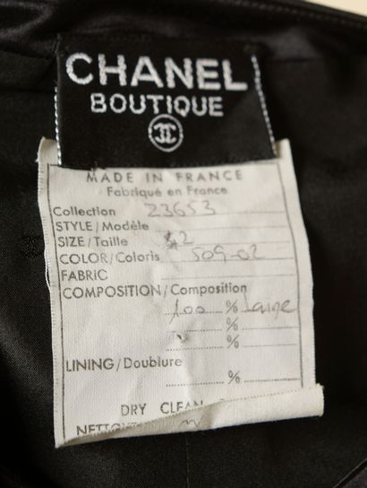 null CHANEL.
Robe de cocktail en laine noire soulignée de galons de soie noire, droite,...