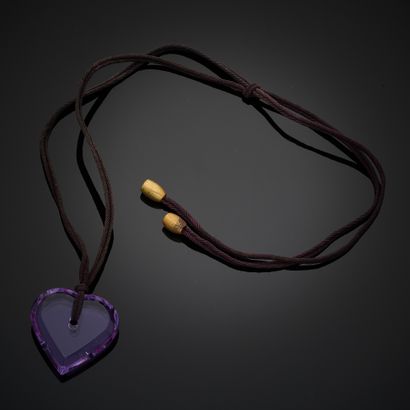 null BACCARAT.
Pendentif coeur en cristal violet taillé avec un cordon marron. Signé....