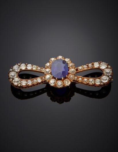 null 18k yellow gold bow brooch presenting an oval-cut sapphire weighing approx....