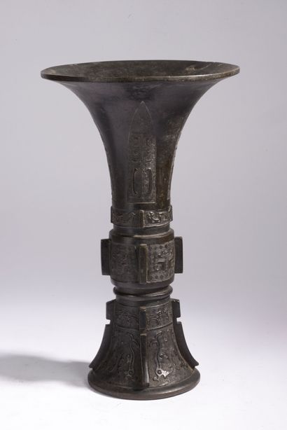 null CHINA.
Brown patina bronze "gu" shaped vase with incised decoration of archaizing...