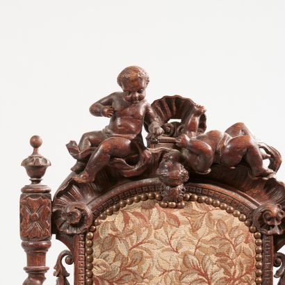 null High-back chair in carved oak, the back surmounted by a shell and playing putti,...