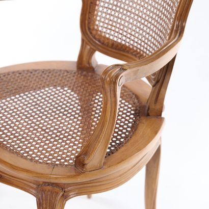 null Caned armchair in molded and carved wood, the rounded back decorated with flowers,...
