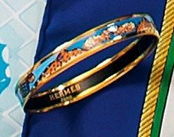 HERMES Paris Bracelet rigide en métal doré à décor d'un galon de panthères et brandebourgs...