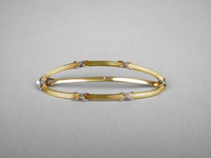 null PINCE à CHEVEUX, l'anneau ovale bombé en or jaune strié 18K à six rubans croisés...