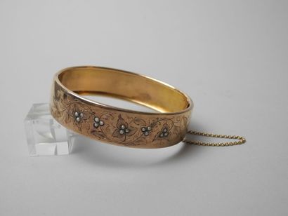 null BRACELET ovale rigide à une charnière en or jaune 18K. Il forme un large galon...