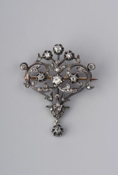 null BROCHE en or jaune 18K et argent ajourée de volutes affrontées et fleurons sertis...