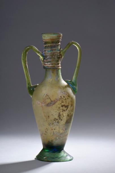 null E Amphorisque munie de deux anses, le col orné de fins filets. Verre vert. Époque...