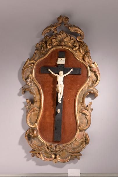 null Crucifix en ivoire dans un cadre en bois sculpté, stuqué et doré de style rocaille...