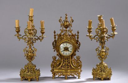 null Garniture de cheminée en bronze doré. La pendule à cadran blanc surmonté d'un...