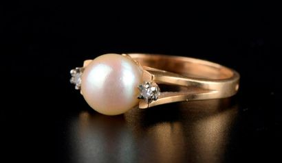 null Bague en or jaune 18K ornée d'une perle de culture épaulée par deux petits diamants.

Doigt...