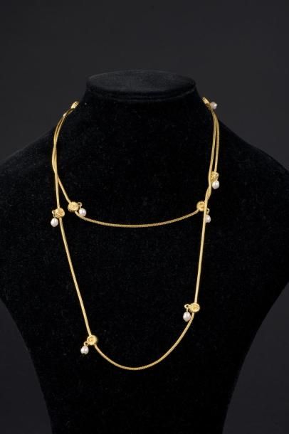 null Sautoir en métal doré retenant neuf perles fantaisie de forme baroque en pampille....