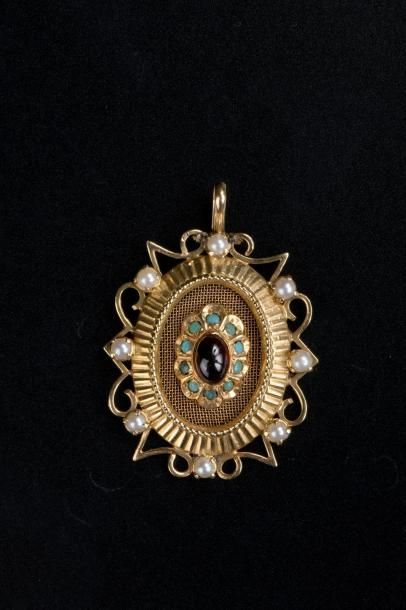 null Pendentif ovale en or jaune 18K, le centre serti de cabochons de grenat et turquoise...