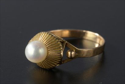 null Bague en or jaune 18k piquée d'une perle de culture posée sur un drapé rayonnant.
Doigt...