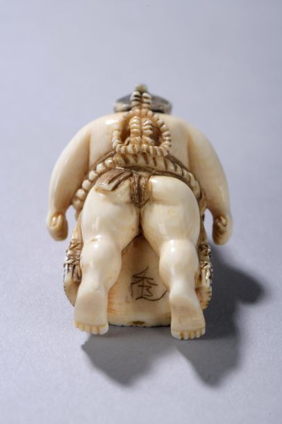 null JAPON, début du XXe siècle. 
Netsuke signé représentant un sumo au pagne debout....