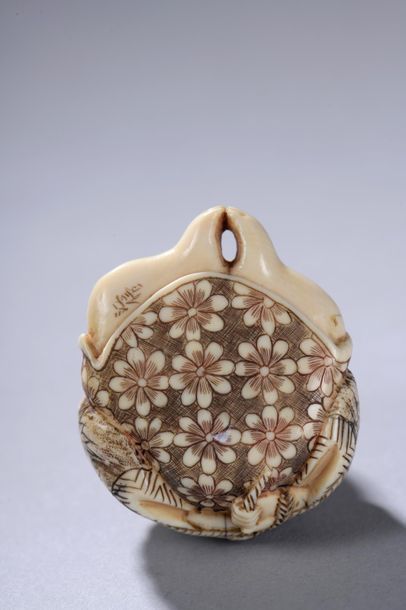 null JAPON, début du XXe siècle. 
Netsuke signé représentant un personnage assis,...