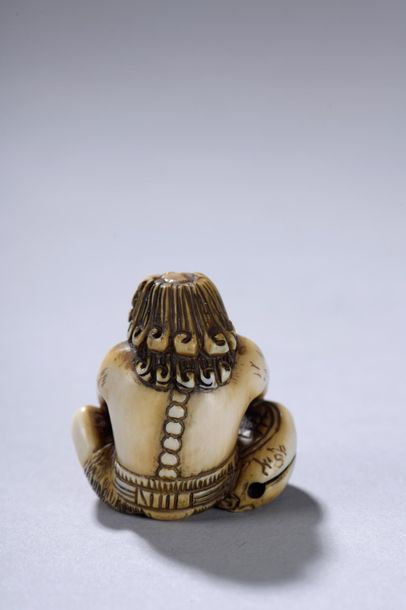 null JAPON, époque MEIJI (1868-1912). 
Netsuke signé représentant un oni assis tenant...